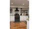 Well-lit kitchen features white cabinets, stainless steel appliances, and floating shelves at 8747 Mesquite Row, Lone Tree, CO 80124
