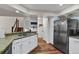 Kitchen with stainless steel refrigerator, granite countertops, white cabinets, and open floor plan at 8747 Mesquite Row, Lone Tree, CO 80124