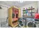 Bright laundry area with a sauna, washer, dryer, and shelving for organized convenience at 8747 Mesquite Row, Lone Tree, CO 80124