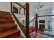 Staircase with wood stairs and cable railing overlooking a living area with fireplace at 8747 Mesquite Row, Lone Tree, CO 80124