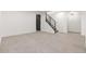 A finished basement area with carpeted floors and staircase, offering a versatile space for recreation or storage at 9197 W Woodard Dr, Lakewood, CO 80227