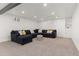 Finished basement featuring a cozy sectional sofa with stylish pillows, creating an inviting lounge area at 9197 W Woodard Dr, Lakewood, CO 80227