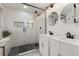 Modern bathroom with glass shower, dual vanity with black fixtures, and tiled floors at 9197 W Woodard Dr, Lakewood, CO 80227