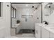 Modern bathroom with frameless glass shower, dual vanity with black hardware, and sleek design at 9197 W Woodard Dr, Lakewood, CO 80227