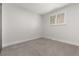 A clean and simple bedroom with a window providing natural light, complemented by neutral-toned carpet and walls at 9197 W Woodard Dr, Lakewood, CO 80227