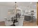 Stylish dining area adjacent to a modern kitchen with island seating and updated appliances at 9197 W Woodard Dr, Lakewood, CO 80227