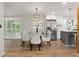 Elegant dining area with modern chandelier and views of the kitchen's stainless appliances and center island at 9197 W Woodard Dr, Lakewood, CO 80227