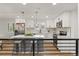 Modern kitchen with white cabinets, marble countertops, stainless steel appliances, and trendy pendant lighting at 9197 W Woodard Dr, Lakewood, CO 80227