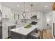 Bright kitchen featuring white cabinetry, marble countertops, stainless steel appliances, and modern pendant lighting at 9197 W Woodard Dr, Lakewood, CO 80227