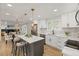 Bright kitchen with white cabinetry, marble backsplash, and a center island open to the dining area at 9197 W Woodard Dr, Lakewood, CO 80227