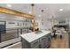 Open floorplan featuring kitchen with island, bar seating, and seamless connection to dining and living spaces at 9197 W Woodard Dr, Lakewood, CO 80227