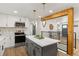 Updated kitchen boasts modern appliances, a center island with seating, and views into the living area at 9197 W Woodard Dr, Lakewood, CO 80227