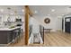 Open-concept living space featuring modern kitchen with island, wood accents, and stylish design flowing into the living area at 9197 W Woodard Dr, Lakewood, CO 80227