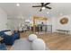 Open-concept living area with hardwood floors, stylish furniture, and a clear view into the kitchen and dining space at 9197 W Woodard Dr, Lakewood, CO 80227