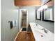 Bathroom featuring a double sink vanity, two mirrors and lights, with a shower behind a glass door at 85 Yank Way, Lakewood, CO 80228