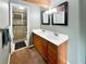 Bathroom featuring a double sink vanity, two mirrors and lights, with a shower behind a glass door at 85 Yank Way, Lakewood, CO 80228