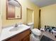 Simple bathroom featuring a single sink vanity, toilet, and a framed mirror at 85 Yank Way, Lakewood, CO 80228