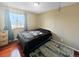 Bedroom with hardwood floors, a black bedspread, and a bright window with view outside at 85 Yank Way, Lakewood, CO 80228