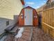 A backyard shed for storage, featuring a white door and matching trim, with a brick pathway leading to its entrance at 85 Yank Way, Lakewood, CO 80228