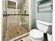 Bathroom showcasing a glass-enclosed tiled shower with mosaic accents, plus a toilet and towel rack at 85 Yank Way, Lakewood, CO 80228