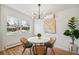 Bright dining area featuring a round table, modern chandelier, and view of the neighborhood at 6170 Estes Ct, Arvada, CO 80004