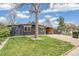 Charming home with lush lawn, mature tree, and inviting covered front seating area at 6170 Estes Ct, Arvada, CO 80004