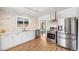Updated kitchen features stainless appliances, white subway tile backsplash and modern lighting at 6170 Estes Ct, Arvada, CO 80004