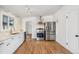 Updated kitchen featuring stainless steel appliances, white cabinetry, and hardwood floors at 6170 Estes Ct, Arvada, CO 80004