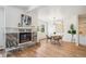 Bright living room with electric fireplace, hardwood floors, and modern light fixture above dining table at 6170 Estes Ct, Arvada, CO 80004