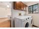 Laundry area with wood cabinets, appliances, and a window for natural light at 4116 W 111Th Cir, Westminster, CO 80031
