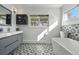 Bright bathroom features a soaking tub, black and white tile, and a modern sink at 5390 Rosemary Ln, Denver, CO 80221