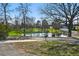 Scenic view of a tranquil pond surrounded by lush greenery and mature trees in a peaceful community setting at 5390 Rosemary Ln, Denver, CO 80221
