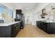 Modern kitchen features stainless steel appliances, quartz countertops, dark cabinetry, and a bright window at 5390 Rosemary Ln, Denver, CO 80221
