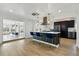 Open concept kitchen with bar seating, modern pendants, stainless steel appliances, and bright natural light at 5390 Rosemary Ln, Denver, CO 80221