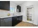 Stylish kitchen features stainless steel appliances, quartz countertops, dark cabinetry, and a bright window at 5390 Rosemary Ln, Denver, CO 80221