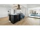 Modern kitchen with central island, white countertops, dark cabinetry, and access to the dining area at 5390 Rosemary Ln, Denver, CO 80221