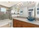Updated bathroom boasts modern fixtures, stylish mirror, wood cabinets, and a sleek shower-tub combo at 8627 Gold Peak Pl # C, Highlands Ranch, CO 80130