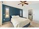 Bedroom with a blue accent wall, plush carpeting, vaulted ceilings, and a closet with built-in shelving at 8627 Gold Peak Pl # C, Highlands Ranch, CO 80130
