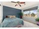 Relaxing bedroom with a large window offering scenic views, complemented by stylish decor and a ceiling fan at 8627 Gold Peak Pl # C, Highlands Ranch, CO 80130