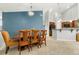 A bright dining area has stylish chairs, a modern light fixture, and a view to the kitchen at 8627 Gold Peak Pl # C, Highlands Ranch, CO 80130