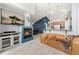 Open living room with a fireplace and a mounted television; flows into the kitchen with bar stool seating at 8627 Gold Peak Pl # C, Highlands Ranch, CO 80130
