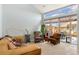 Bright living room featuring large windows, a tan leather sofa, plants, and access to an outdoor deck at 8627 Gold Peak Pl # C, Highlands Ranch, CO 80130