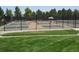 Several community pickleball courts behind a black fence overlooking a grassy park at 8627 Gold Peak Pl # C, Highlands Ranch, CO 80130