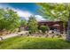 Community pool area with covered patio seating, lush greenery, and well-maintained lawn at 8627 Gold Peak Pl # C, Highlands Ranch, CO 80130