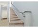 Carpeted staircase with light blue walls, white trim, and a handrail, leading to the upper level at 8627 Gold Peak Pl # C, Highlands Ranch, CO 80130