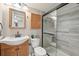 Bathroom featuring a modern vanity, toilet, and a tiled walk-in shower with glass door at 1629 S Deframe St # A1, Lakewood, CO 80228