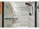 Close up of a shower with custom tile, a glass door, and multiple shower heads at 1629 S Deframe St # A1, Lakewood, CO 80228