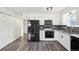 Bright eat-in kitchen features wood-look floors, white cabinets, and stainless steel appliances at 1629 S Deframe St # A1, Lakewood, CO 80228
