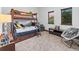 Comfortable bedroom with bunk beds, plush chair and scenic mountain views through two windows at 12947 Lazy Dog Ln, Littleton, CO 80127
