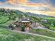 Stunning exterior of a multi-level home with a two-car garage and mountain views at sunset at 12947 Lazy Dog Ln, Littleton, CO 80127